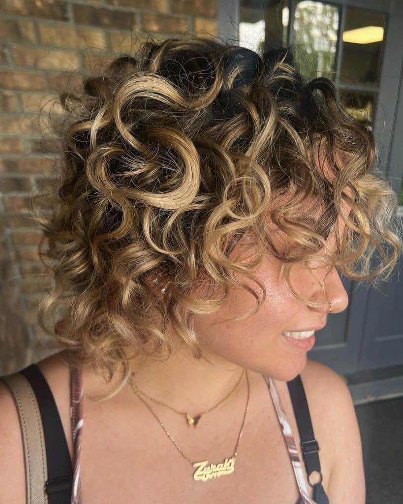 Woman with curly hair and new balayage coloring.
