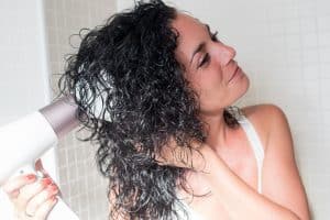 woman diffusing her curly hair after washing