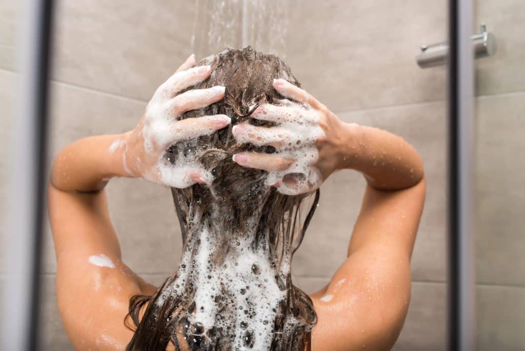 woman washing her hair after applying color