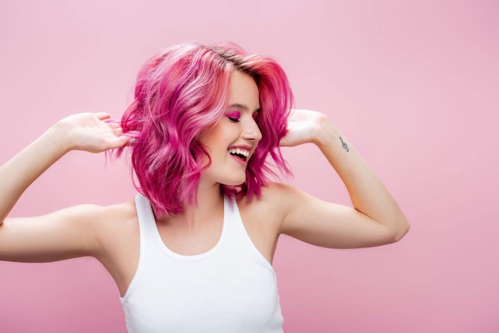 Woman with pink colored hair on a pink background