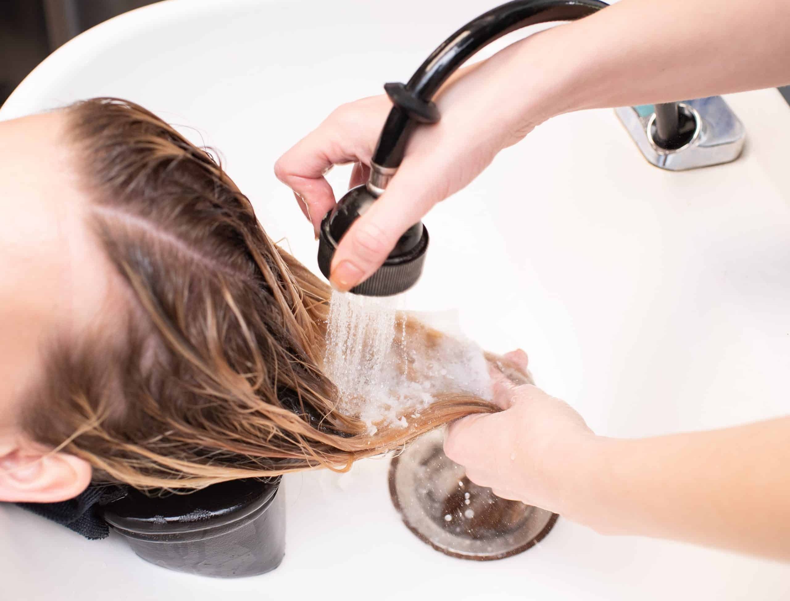 Client having their hair washed at a hair salon.