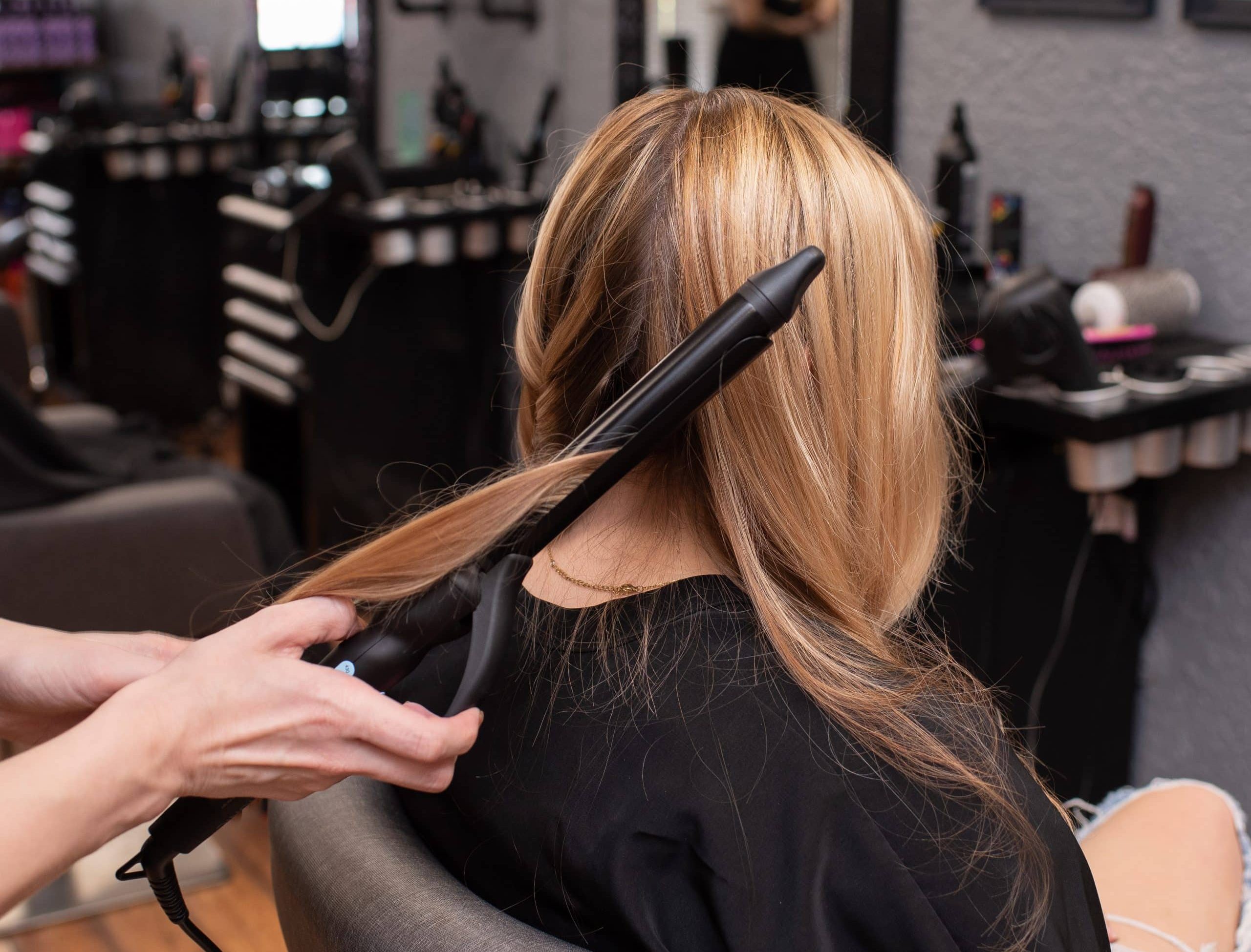 Hair stylist curling a client's hair